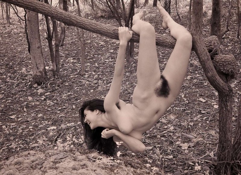 Naked women hanging on a tree